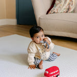 A baby playing comfortably on the rug-like shell design beachcomber blue playmat from totter and tumble | SKU: 26 BEACH/GATHER XL, 26 BEACH/GATHER STD, 26 BEACH/GATHER COMP