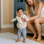 A woman helping her baby take some steps safely and comfortably on the beachcomber playmat | SKU: 26 BEACH/GATHER XL, 26 BEACH/GATHER STD, 26 BEACH/GATHER COMP