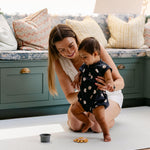 A woman helping her baby take some steps safely and comfortably on a beachcomber totter and tumble playmat. easy to clean, rug-like and non toxic. | SKU: 26 BEACH/GATHER XL, 26 BEACH/GATHER STD, 26 BEACH/GATHER COMP