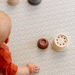 A baby reaching for some toys on a safe non toxic beachcomber playmat suitable from birth | SKU: 26 BEACH/GATHER XL, 26 BEACH/GATHER STD, 26 BEACH/GATHER COMP