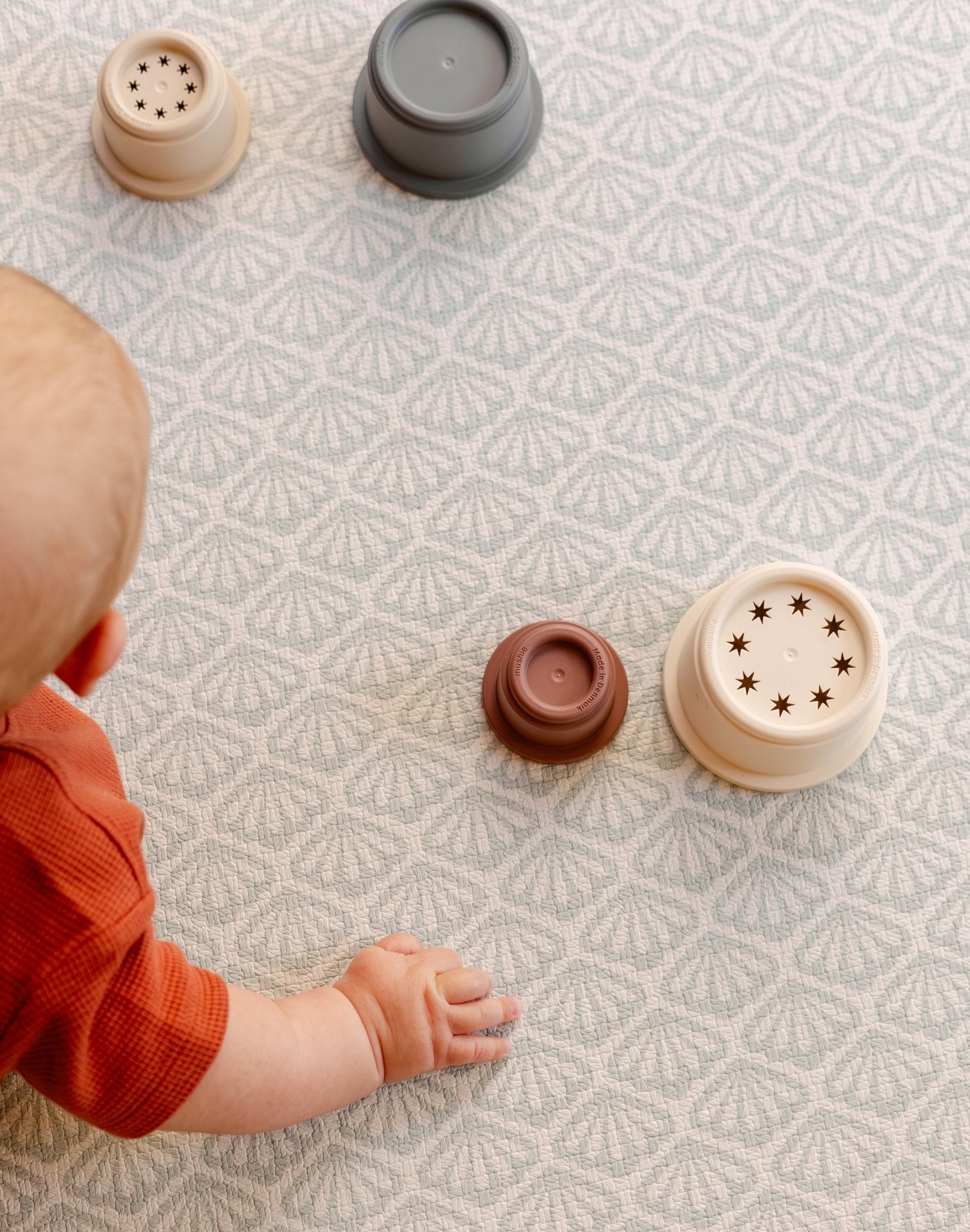A baby reaching for some toys on a safe non toxic beachcomber playmat suitable from birth | SKU: 26 BEACH/GATHER XL, 26 BEACH/GATHER STD, 26 BEACH/GATHER COMP