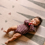 Baby lying on The Counter reversible memory foam playmat by Totter + Tumble