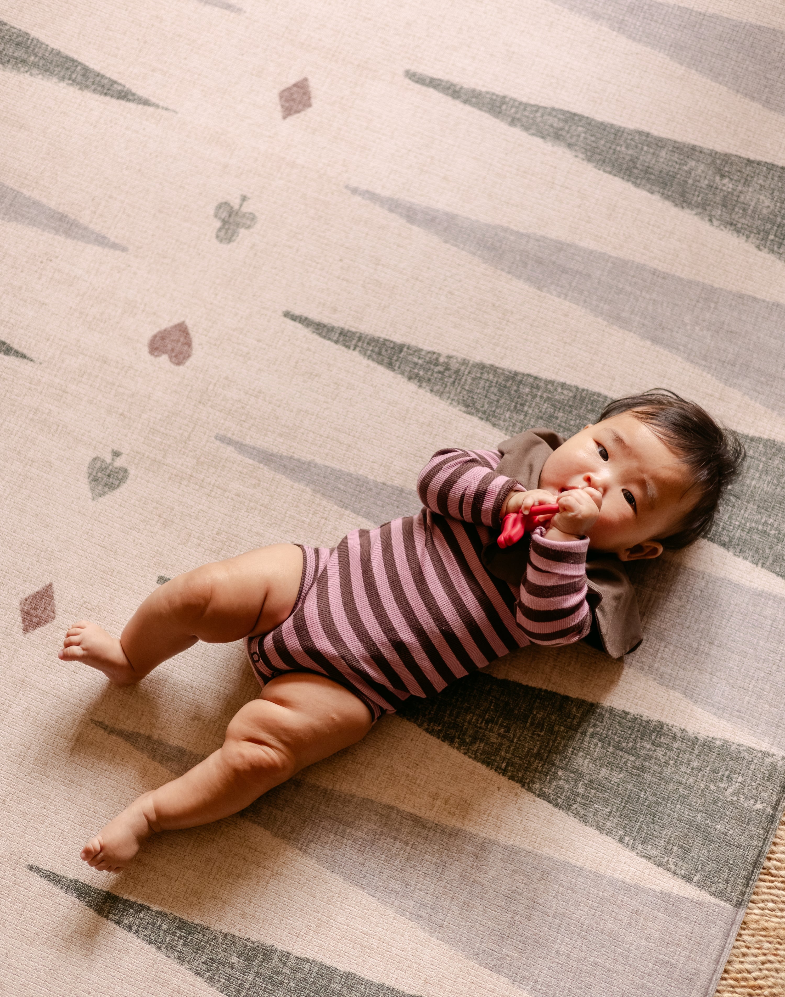 Baby lying on The Counter reversible memory foam playmat by Totter + Tumble