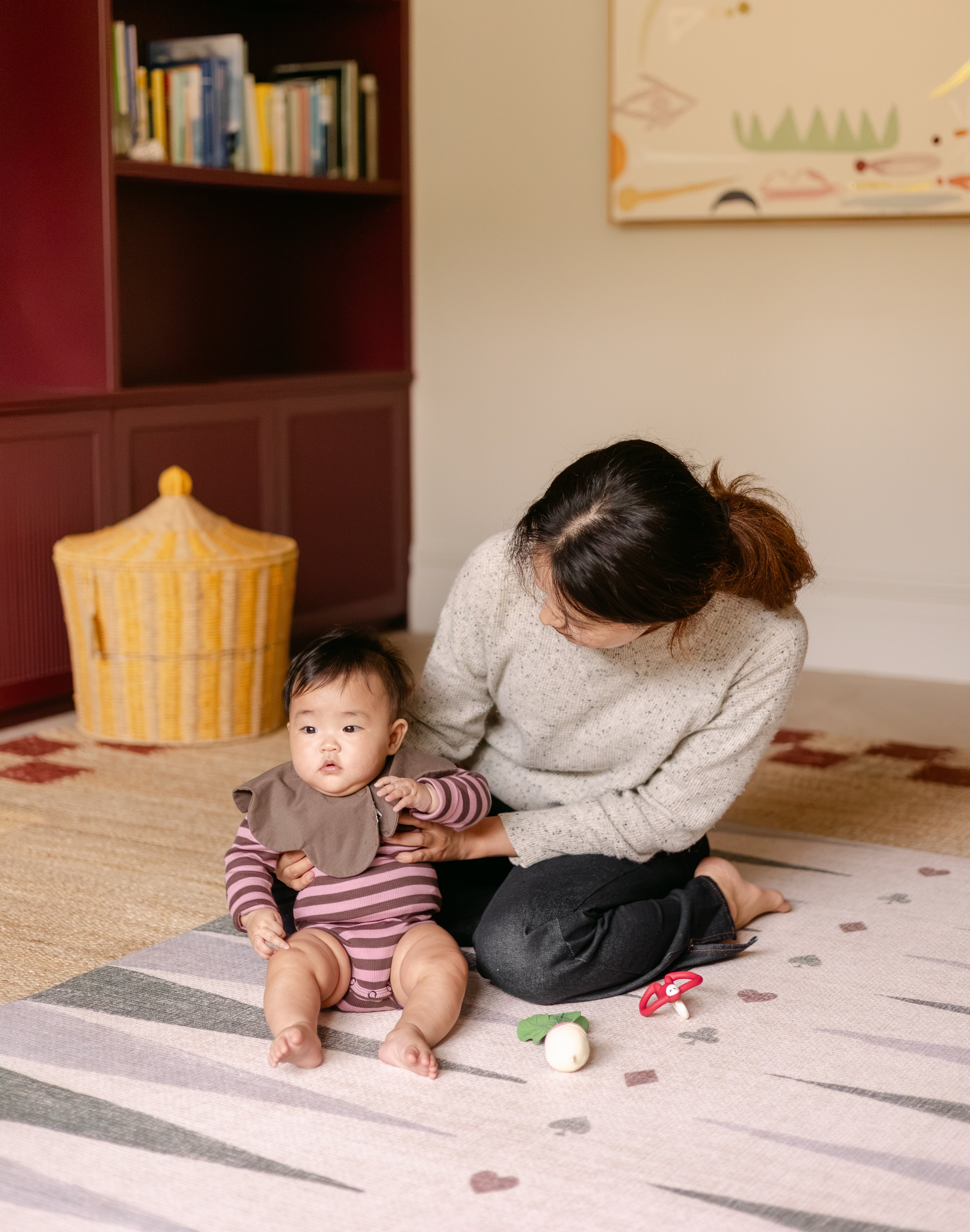 Mum and baby sitting on The Counter wipeable reversible memory foam playmat from Totter + Tumble