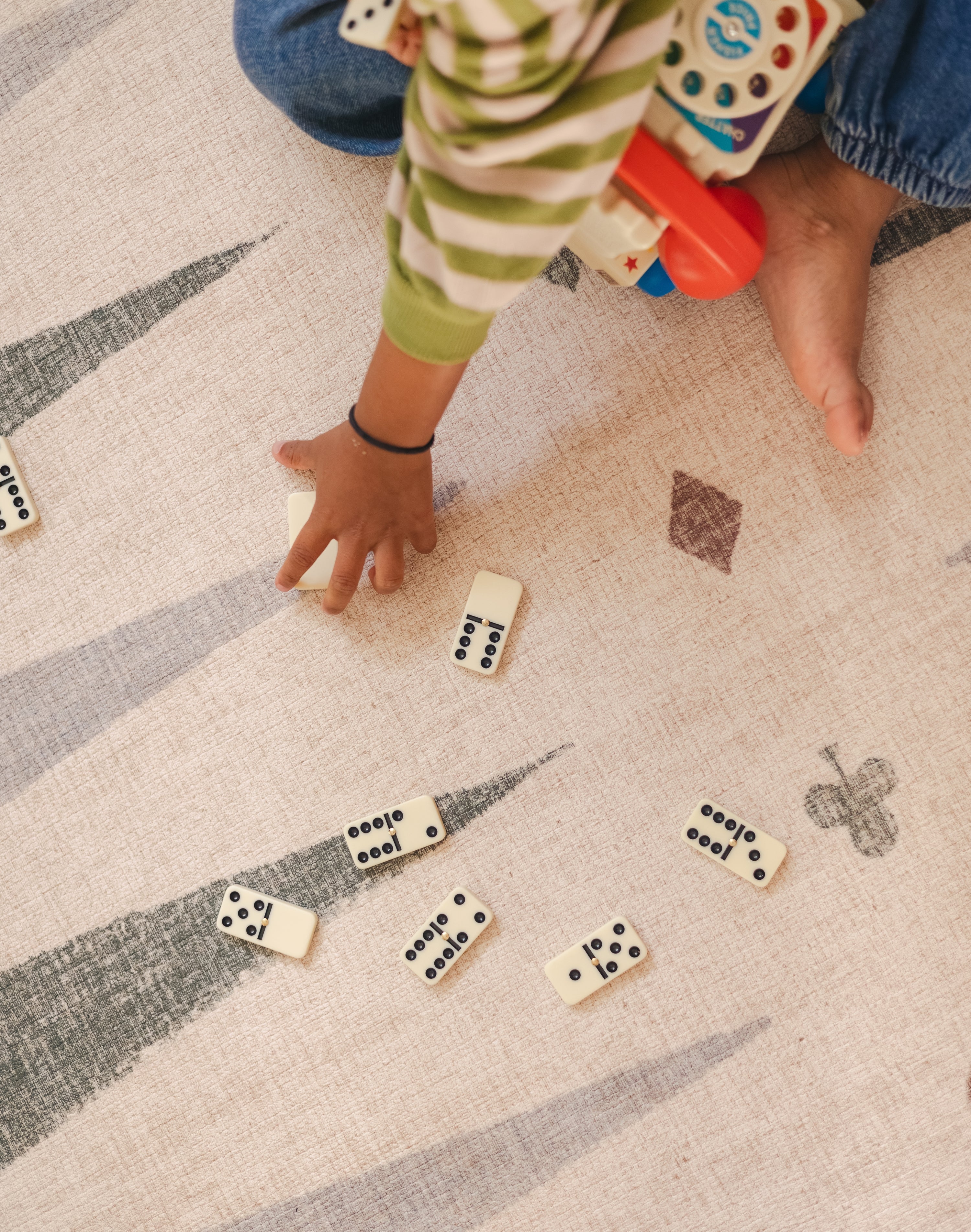 Children playing dominos on The Counter wipeable reversible memory foam playmat from Totter + Tumble