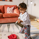 Child playing on The Counter wipeable reversible memory foam playmat from Totter + Tumble