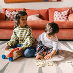 Child and tollder playing games on The Counter wipeable reversible memory foam playmat from Totter + Tumble