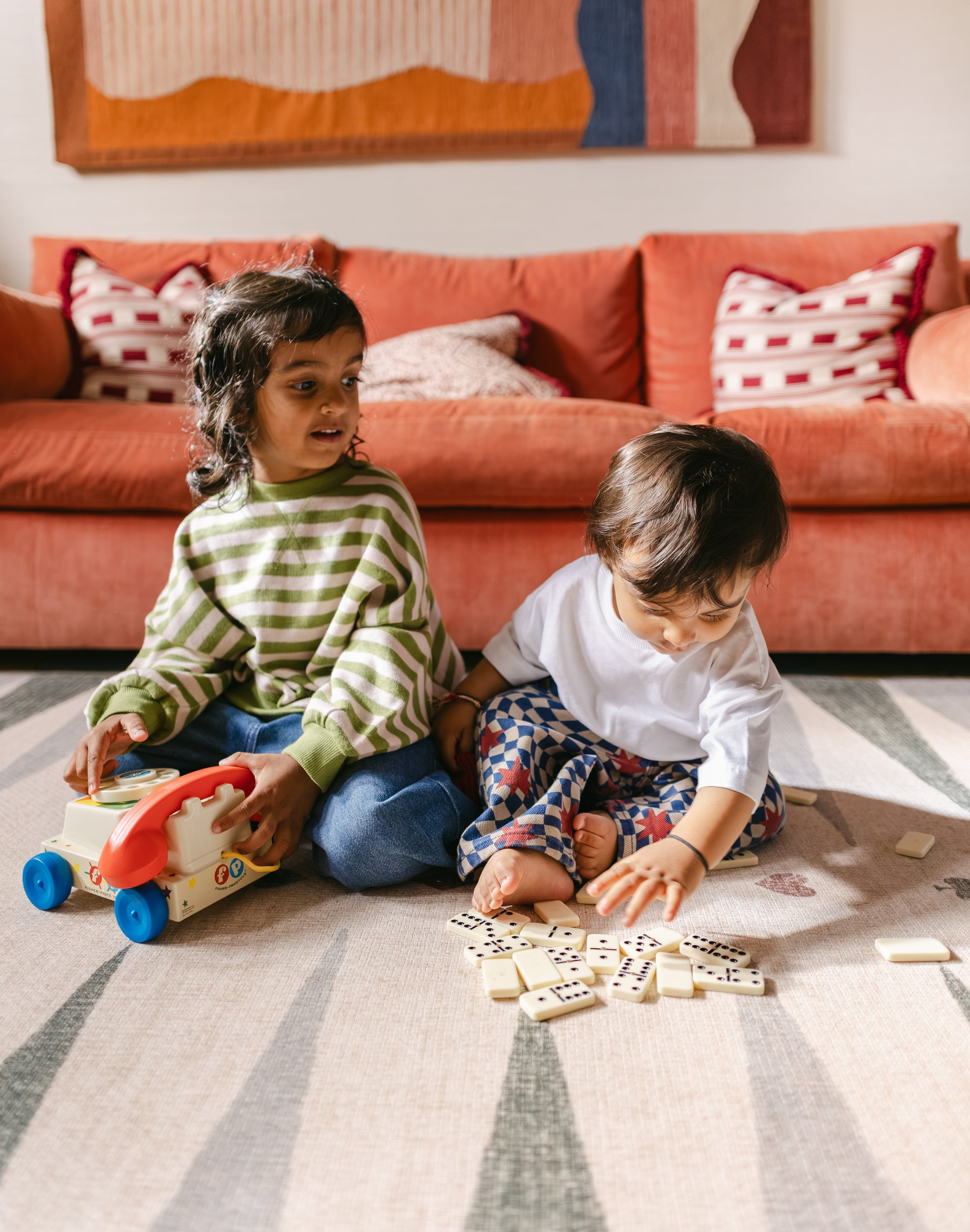 Child and tollder playing games on The Counter wipeable reversible memory foam playmat from Totter + Tumble