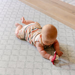 A baby laid on a coastal inspired design playmat from totter and tumble | SKU: 26 BEACH/GATHER XL, 26 BEACH/GATHER STD, 26 BEACH/GATHER COMP