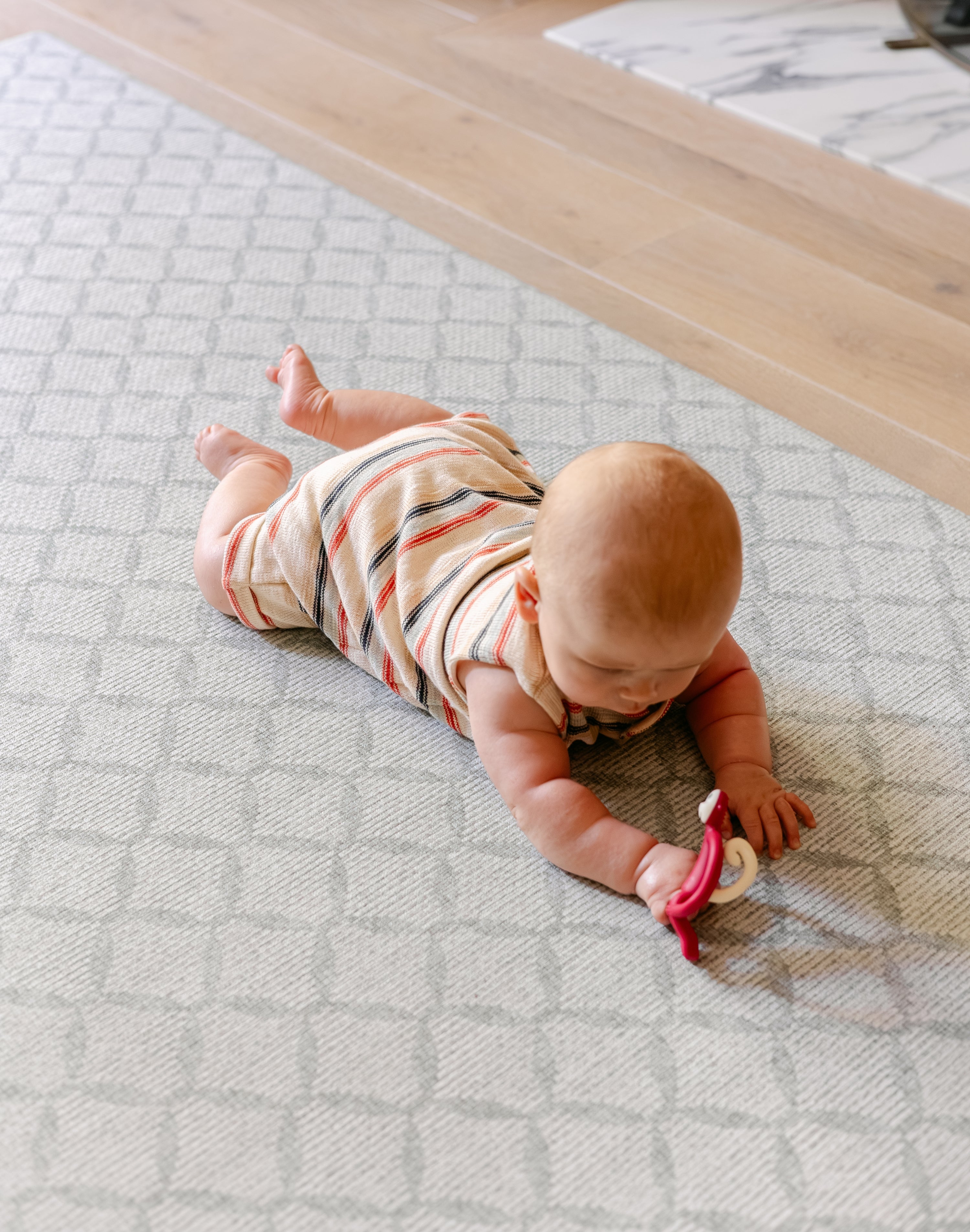 A baby laid on a coastal inspired design playmat from totter and tumble | SKU: 26 BEACH/GATHER XL, 26 BEACH/GATHER STD, 26 BEACH/GATHER COMP