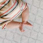 A close up on a baby's feet on the gatherer coastal inspired playmat design | SKU: 26 BEACH/GATHER XL, 26 BEACH/GATHER STD, 26 BEACH/GATHER COMP