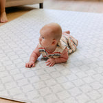 A baby laying on the gatherer playmat from totter and tumble, soft, safe and made from thick memory foam