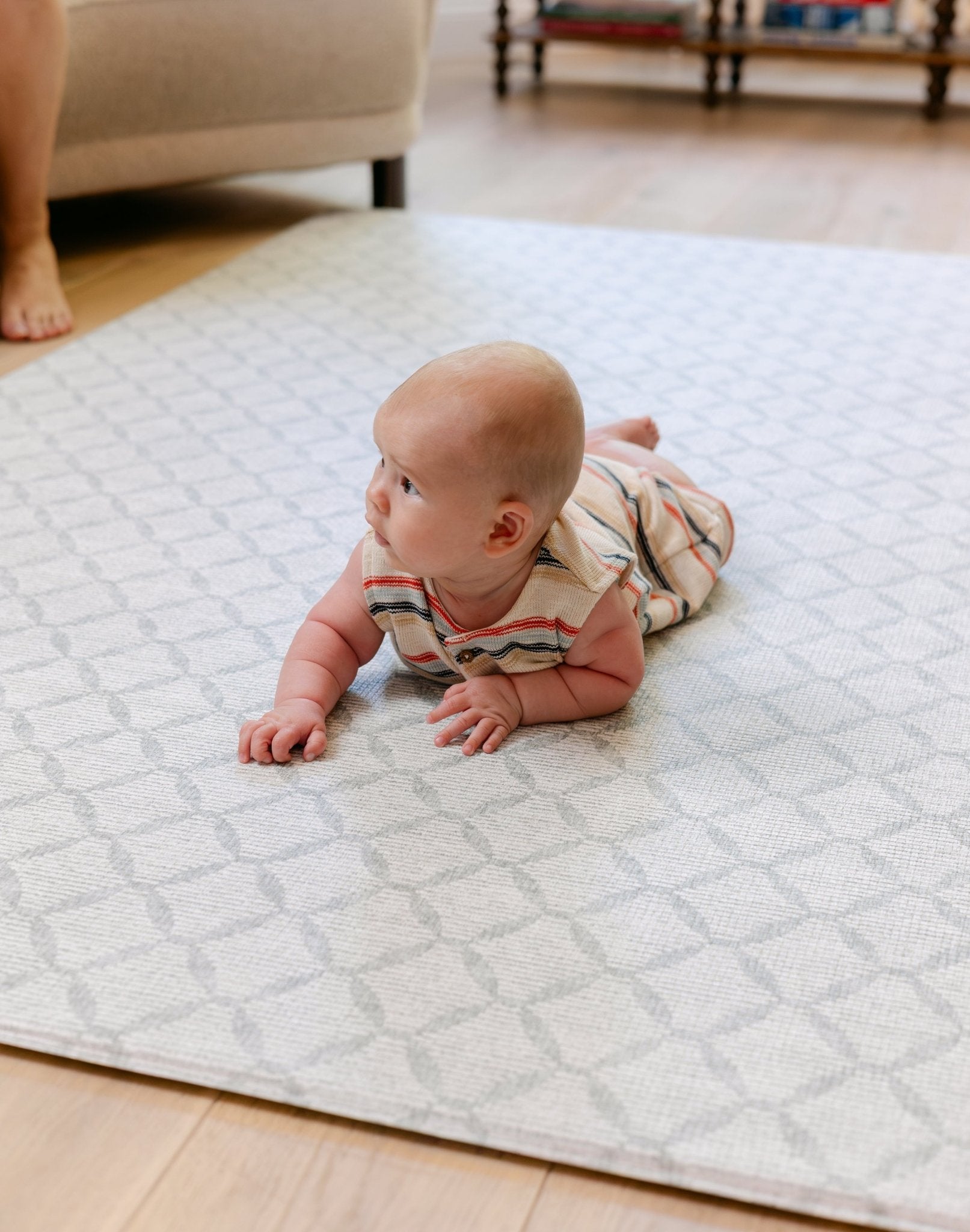 A baby laying on the gatherer playmat from totter and tumble, soft, safe and made from thick memory foam