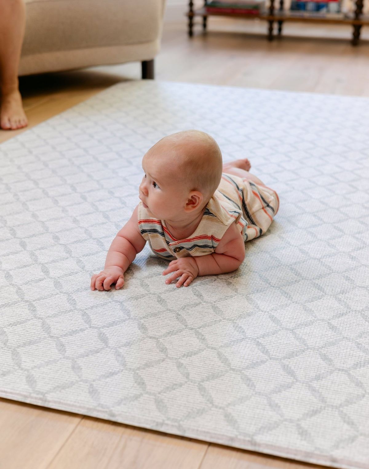 A baby laying on the gatherer playmat from totter and tumble, soft, safe and made from thick memory foam