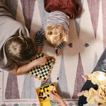 Family playing games on The Roller XL reversible memory foam playmat by Totter + Tumble, the largest one piece playmat on the market