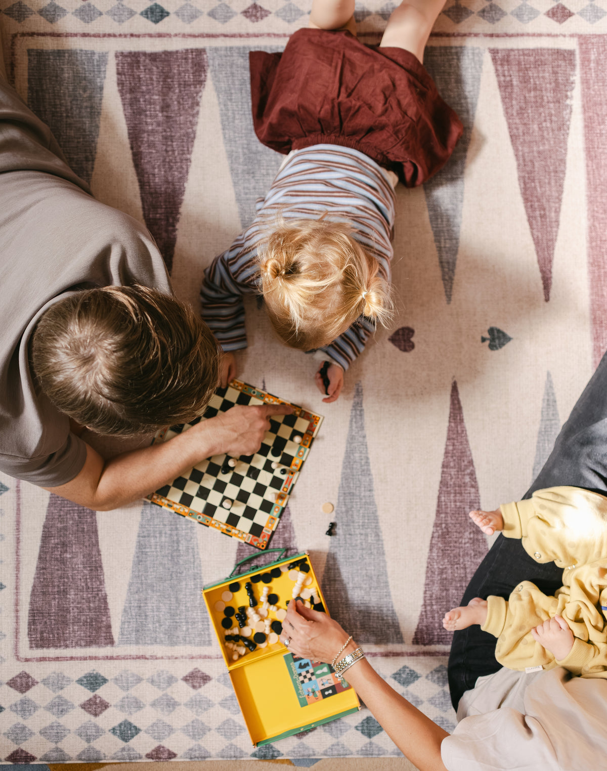 Family playing games on The Roller XL reversible memory foam playmat by Totter + Tumble, the largest one piece playmat on the market