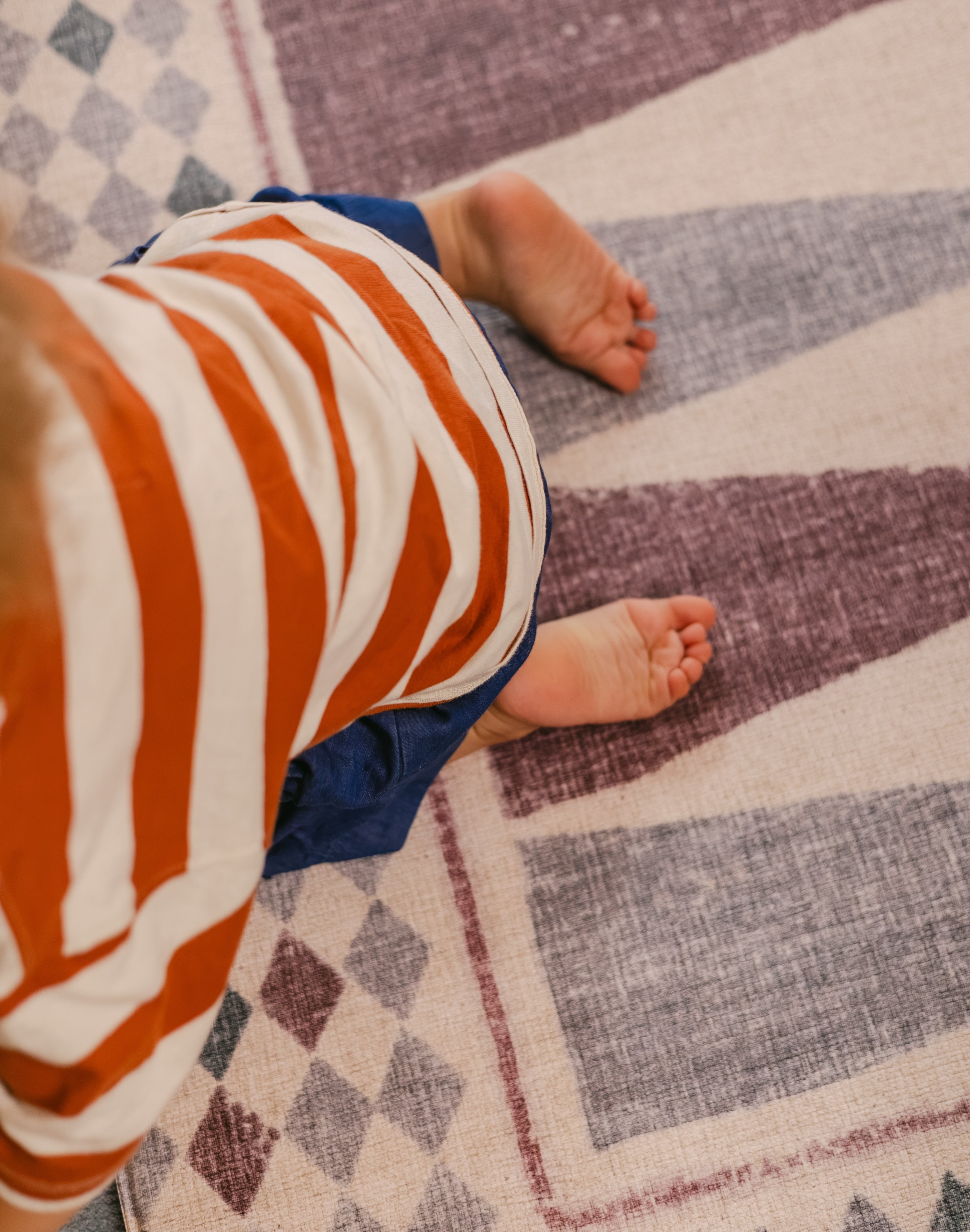 Child playing on The Roller XL reversible memory foam playmat by Totter + Tumble, the largest one piece playmat on the market