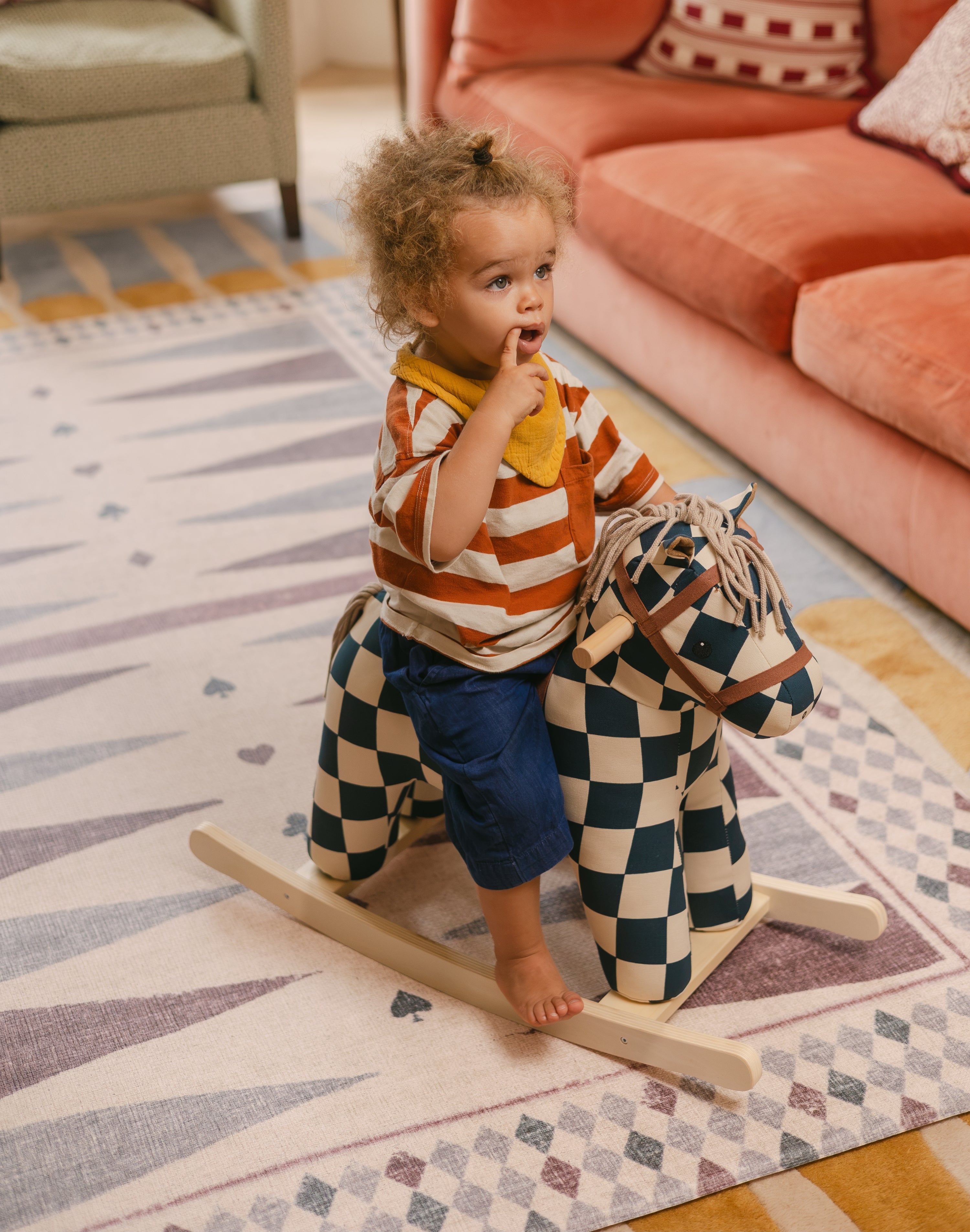Child on a rocking horse on The Roller XL reversible memory foam playmat by Totter + Tumble, the largest one piece playmat on the market