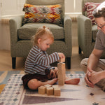 Todder and dad stacking blocks on The Roller XL reversible memory foam playmat by Totter + Tumble, the largest one piece playmat on the market