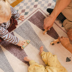 Children playing on The Roller XL reversible memory foam playmat by Totter + Tumble, the largest one piece playmat on the market