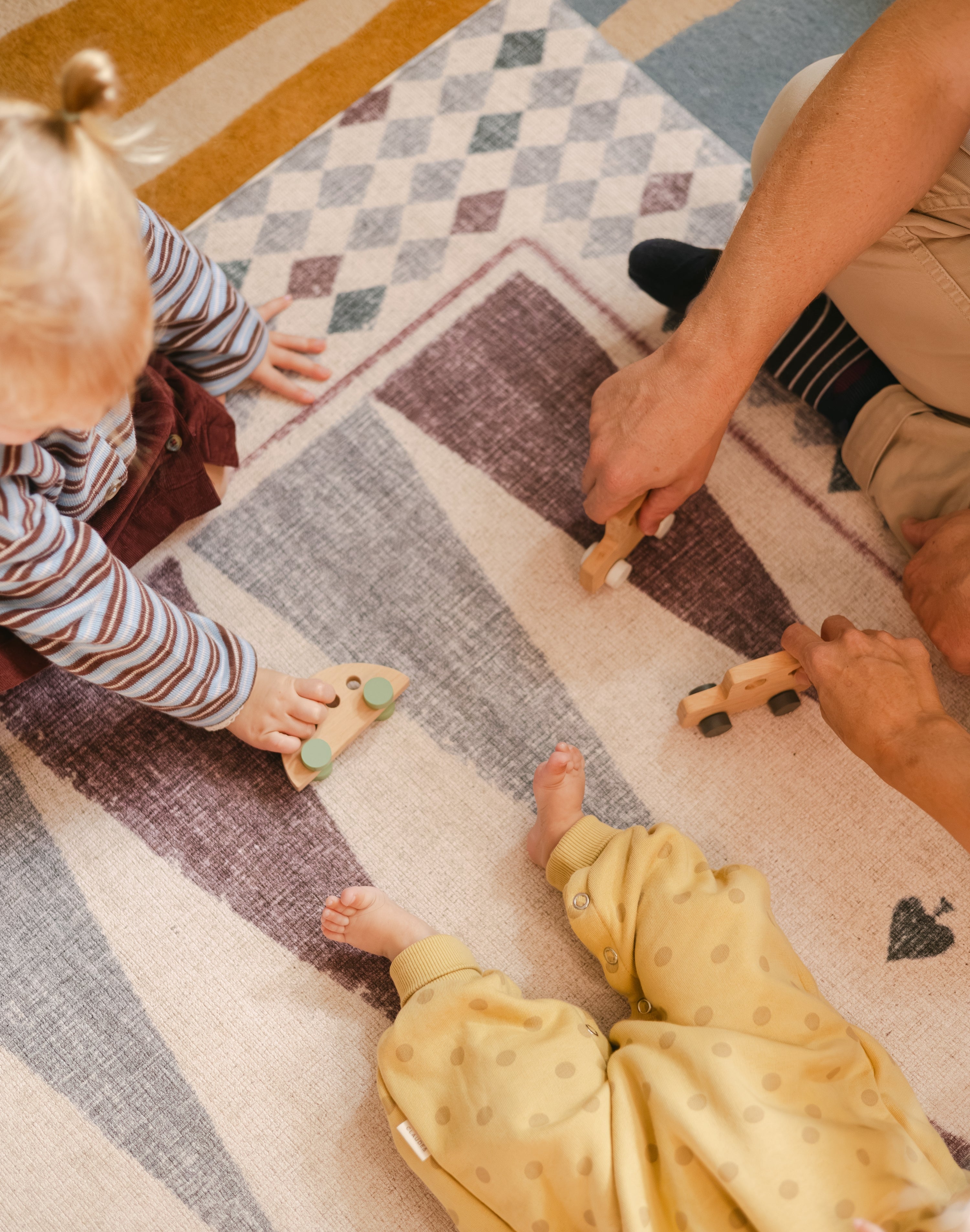 Children playing on The Roller XL reversible memory foam playmat by Totter + Tumble, the largest one piece playmat on the market