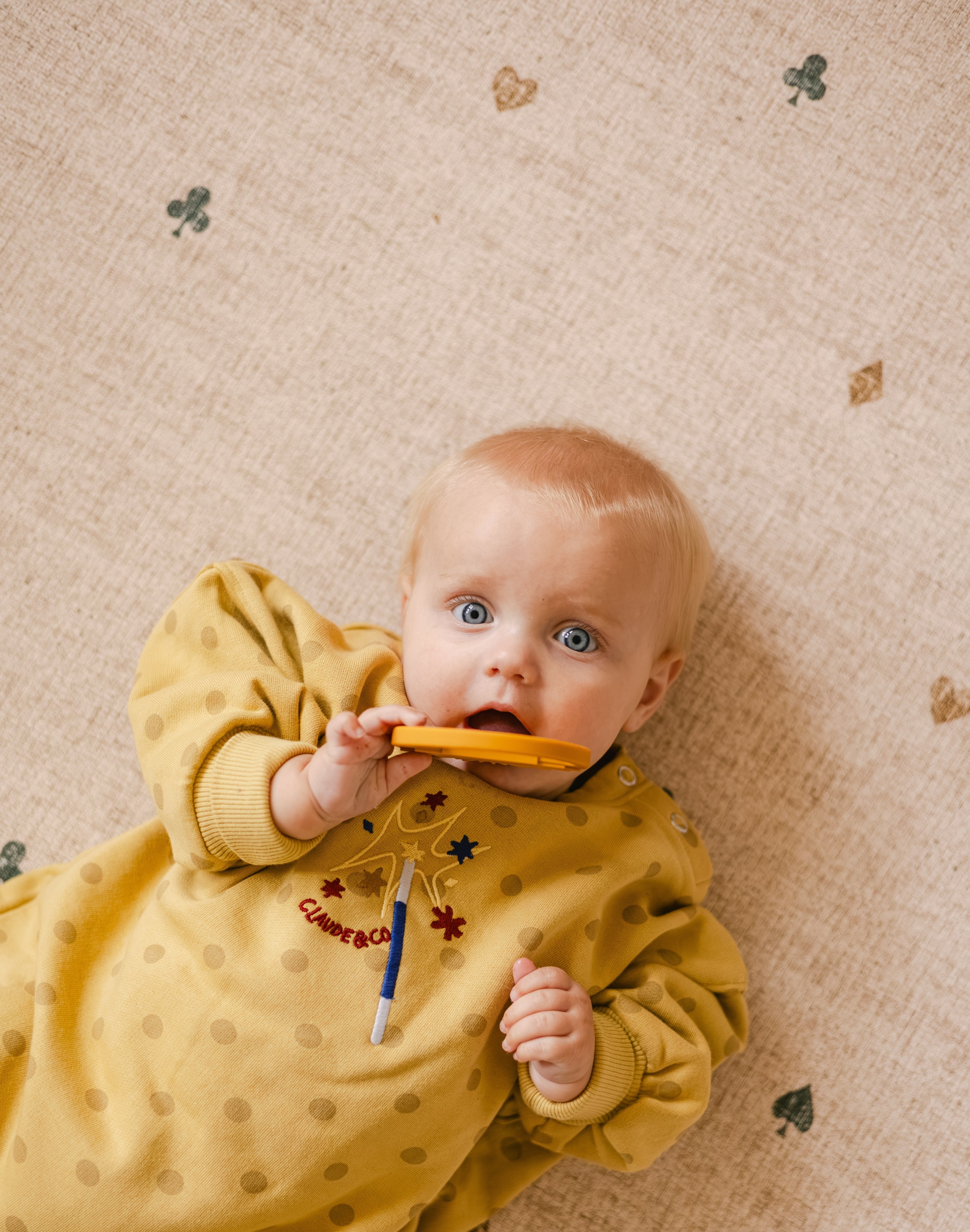 Baby lying down on The Wildcard XL reversible memory foam playmat by Totter + Tumble, the largest one piece playmat on the market