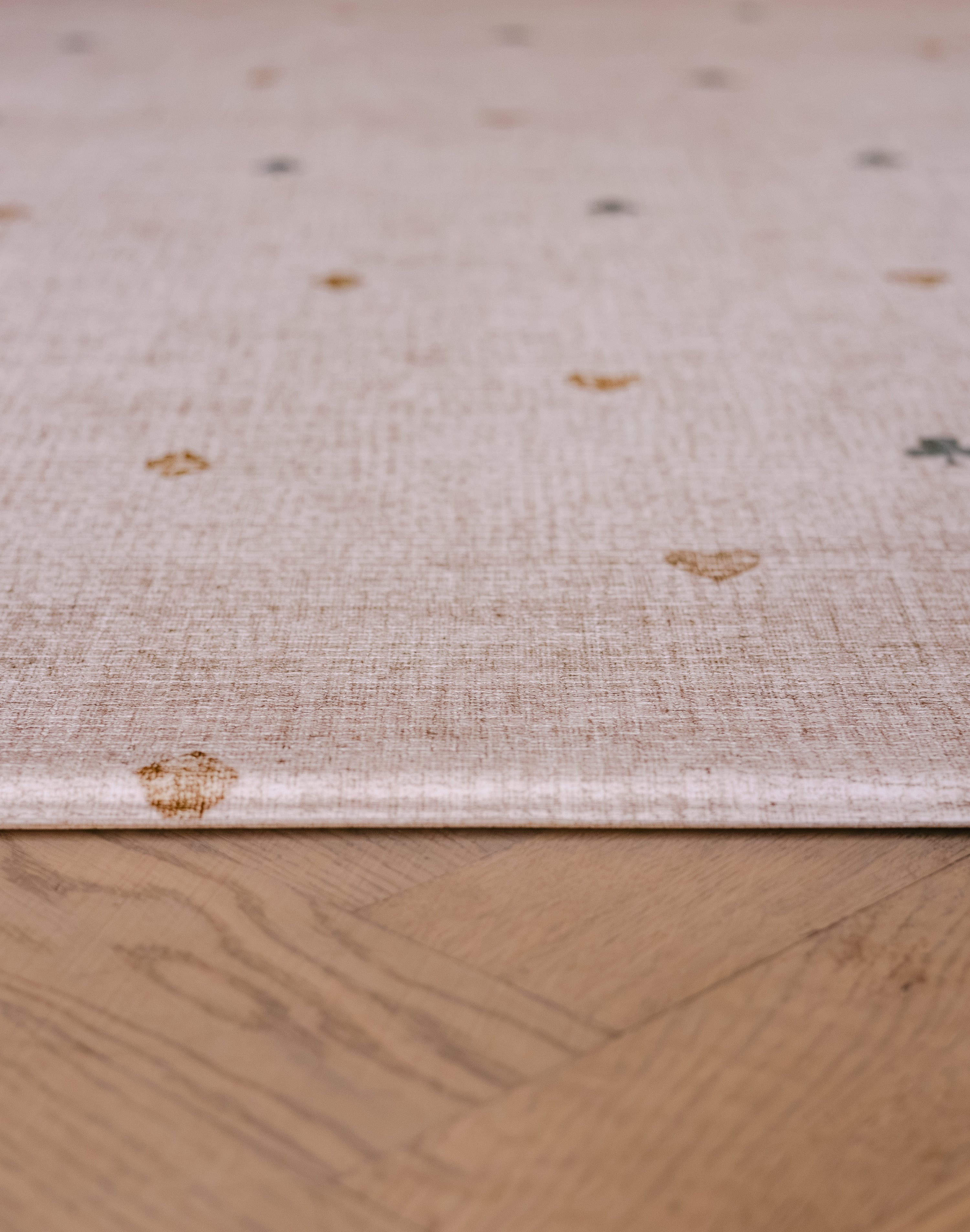 Close-up edge of The Wildcard XL reversible memory foam playmat by Totter + Tumble, the largest one piece playmat on the market