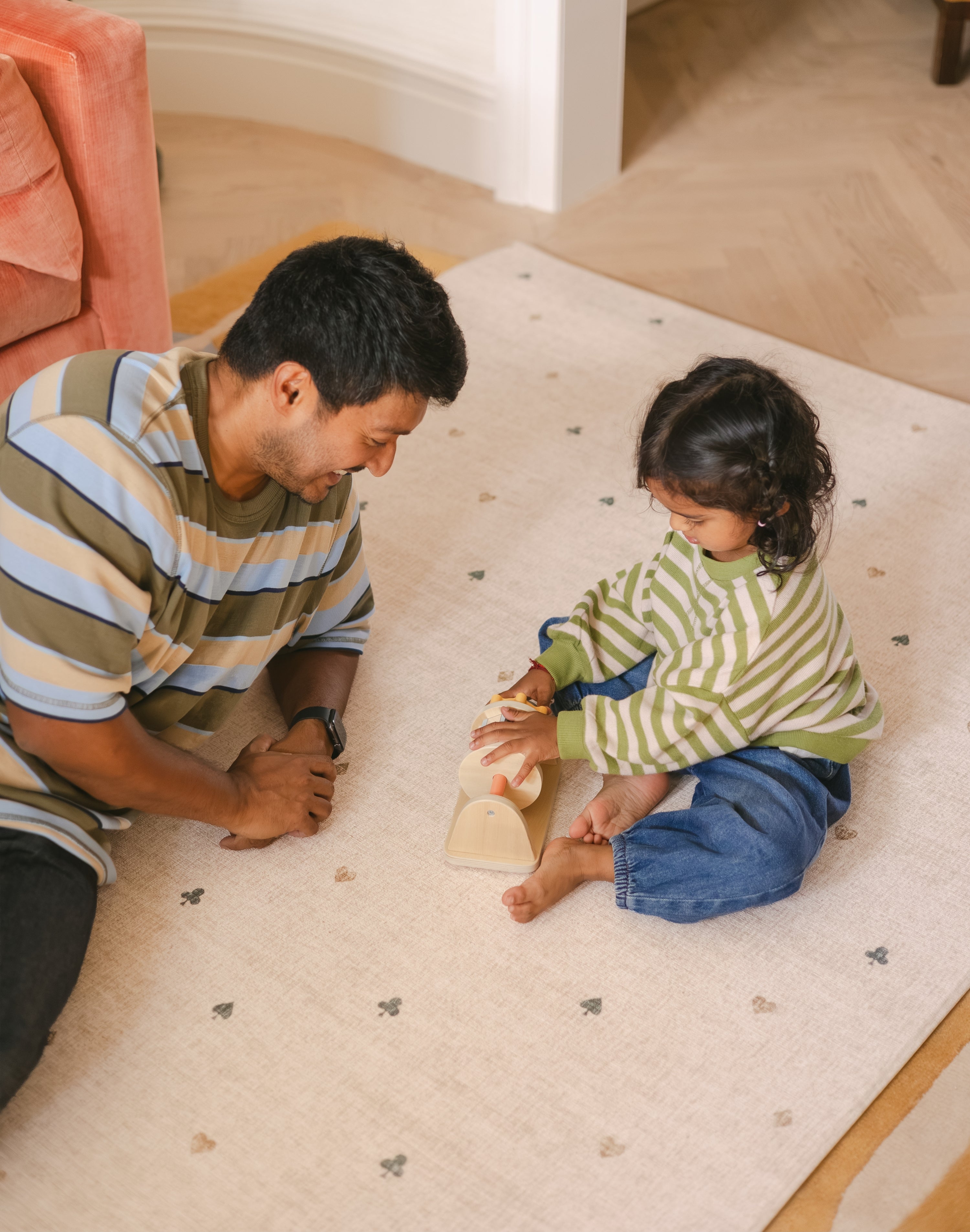Dad and daughter play on The Wildcard XL reversible memory foam playmat by Totter + Tumble, the largest one piece playmat on the market