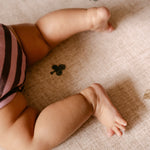 Baby legs on The Wildcard XL reversible memory foam playmat by Totter + Tumble, the largest one piece playmat on the market