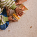 Child playing on The Wildcard XL reversible memory foam playmat by Totter + Tumble, the largest one piece playmat on the market